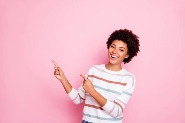 photo of amazing dark skin wavy lady indicating fingers up empty space showing low prices shopping wear striped pullover isolated pastel pink color background - blank sale young women one young woman only imagens e fotografias de stock