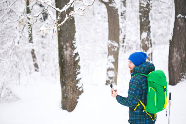 человек ищет направление с компасом в зимнем снежном лесу - orienteering planning mountain climbing compass стоковые фото и изображения