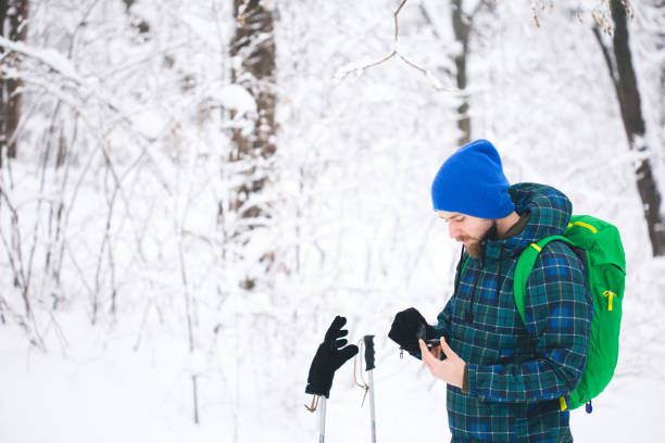 man searching direction with compass in winter snowy forest - orienteering planning mountain climbing compass imagens e fotografias de stock