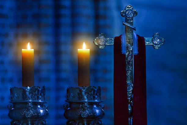 croce del santo vescovo con stola e candele nella cattedrale oscura - church altar indoors dark foto e immagini stock