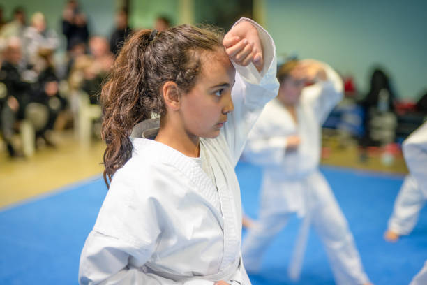 deportes y disciplinas. artes marciales. chica preadolescente durante una clase de karate en el gimnasio - karate child judo belt fotografías e imágenes de stock