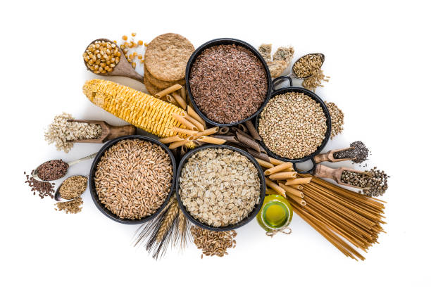 Dietary fiber: large group of wholegrain food shot from above on white background Healthy eating: Top view of wholegrain food and cereal composition isolated on white background. This type of food is rich of fiber and is ideal for dieting. The composition includes wholegrain sliced bread, various kinds of wholegrain pasta, wholegrain crackers, oat flakes, brown rice, dried corn, buckwheat, spelt, flax seed oil and flax seeds. Predominant colors are brown and white. XXXL 42Mp studio photo taken with SONY A7rII and Zeiss Batis 40mm F2.0 CF rice cereal plant stock pictures, royalty-free photos & images