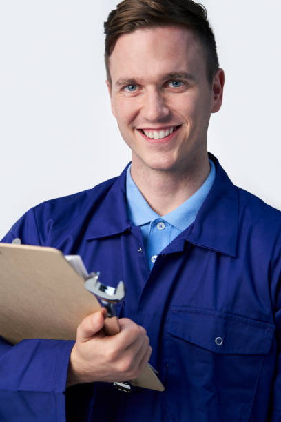 istock Studio Portrait Of Male Engineer With Clipboard And Spanner Against White Background 1178564483