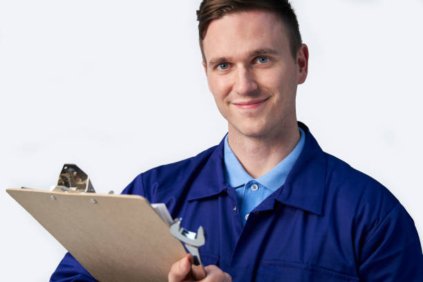 istock Studio Portrait Of Male Engineer With Clipboard And Spanner Against White Background 1178565177