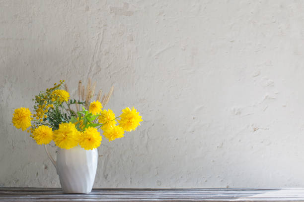 istock yellow summer flowers in jug on white background 1178565195