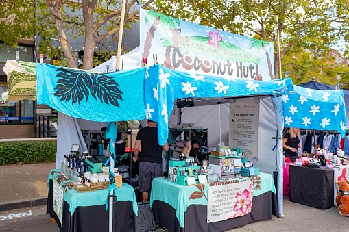 Lafayette, California, United States - September 22, 2019:  Vendor tent for the Coconut Hut, with signs advertising various forms of CBD oil, including oil for skin treatment and vaping, following the legalization of hemp derived products, Lafayette, California, September 22, 2019