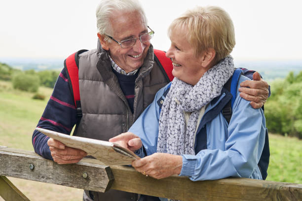 pareja jubilada en vacaciones a pie descansando en la puerta con el mapa - map uk hiking reading fotografías e imágenes de stock