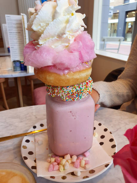 pink strawberry freakshake with sweets, donuts and wipped cream in cafe, extreme milkshake - wipped cream imagens e fotografias de stock