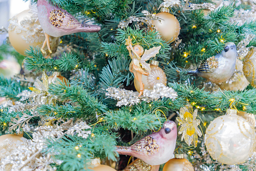 Christmas and New Year holidays background. Christmas tree decorated gold baubles and garlands. Glittering and sparkling. Celebration concept\
