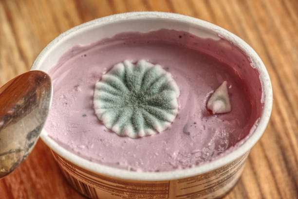 Moldy yogurt on a wooden table background stock photo