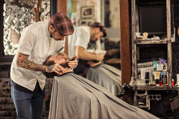 Barber man grooming with scissors of real hipster of the mirrors