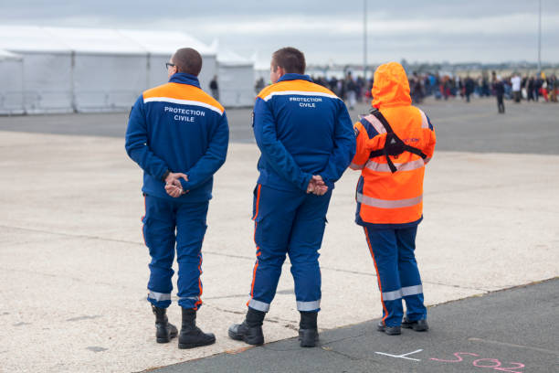 Civil Protection at Paris-Le Bourget Airport Le Bourget, France - September 29 2019: Three rescue workers of the 'Protection Civile' (First Responder) on patrol at Paris-Le Bourget Airport (French: Aéroport de Paris-Le Bourget). The Protection Civile is a civil defence agency of the French Government. french civil protection stock pictures, royalty-free photos & images