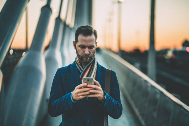 istock Businessman in the city texting on sunset 1178572892