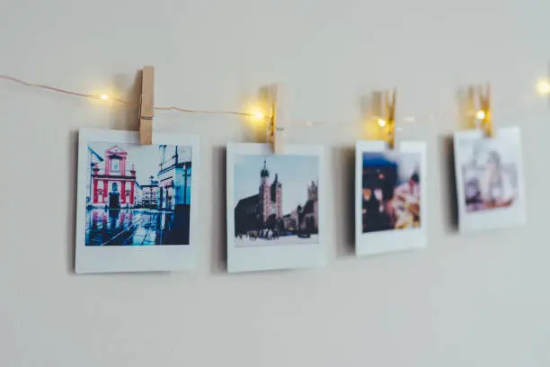Instant photo prints hanging on string with clothespin in studio