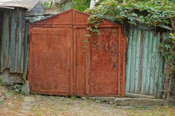 istock old iron red gates in rust and dry vegetation 1178573694