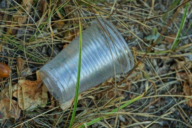 istock white plastic glass lies on the grass in nature 1178574615