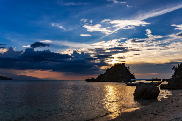 tramonto su una spiaggia vicino al giardino di corallo sull'isola di san antonio, puerto galera, regione orientale di mindoro nelle filippine. - puerto galera foto e immagini stock