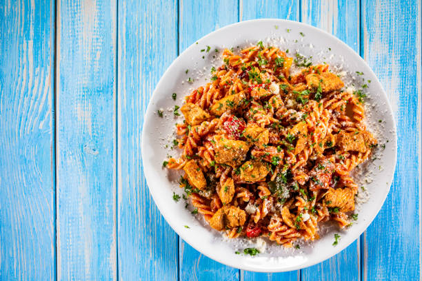 pasta witch chicken meat and vegetables on wooden background - pasta directly above fusilli food imagens e fotografias de stock