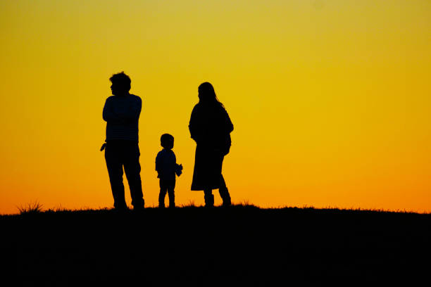 Family standing on the evening of the hill Family standing on the evening of the hill. Shooting Location: Mitaka City, Tokyo 丘 stock pictures, royalty-free photos & images