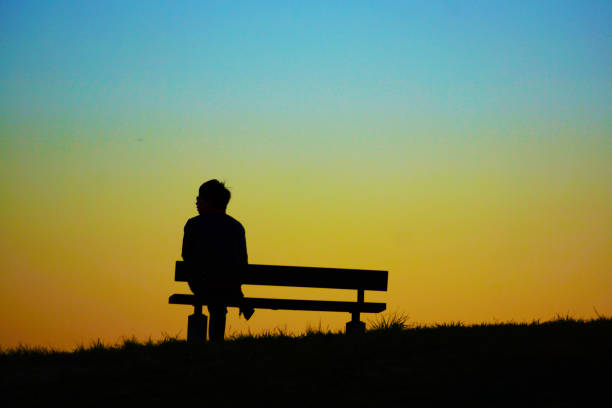 Woman sitting on the evening of the hills of the bench Woman sitting on the evening of the hills of the bench. Shooting Location: Mitaka City, Tokyo senior adult women park bench 70s stock pictures, royalty-free photos & images