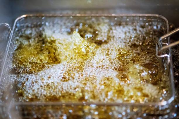 Deep fryers with hot bubbling boiling oil on restaurant kitchen