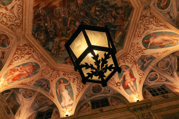 Genova, Italy - January 17, 2018: Interior of a public gallery in Genoa, vintage lamp hangs under colorful fresco painted ceiling