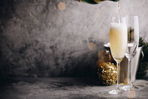 Champagne pouring into glasses and Christmas decorations