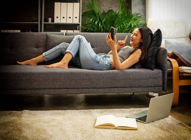 istock The beautiful woman laying down on sofa,using mobile phone,doing activity at home,for holiday,urban lifestyle,blurry light around 1178578959