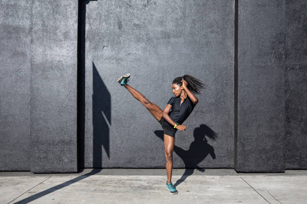 donna afro-americana con dreadlocks in grande forma atletica che si allena e si allena duramente all'aperto - exercising organized group sport outdoors foto e immagini stock