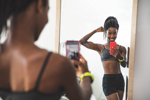 joven mujer deportiva posando para un retrato en casa - bíceps fotos fotografías e imágenes de stock