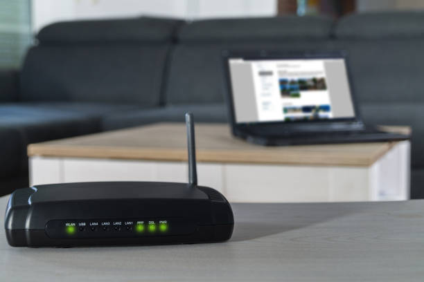 Home internet router on desk. Home internet connection. A wlan router on desk with notbook in background. router stock pictures, royalty-free photos & images