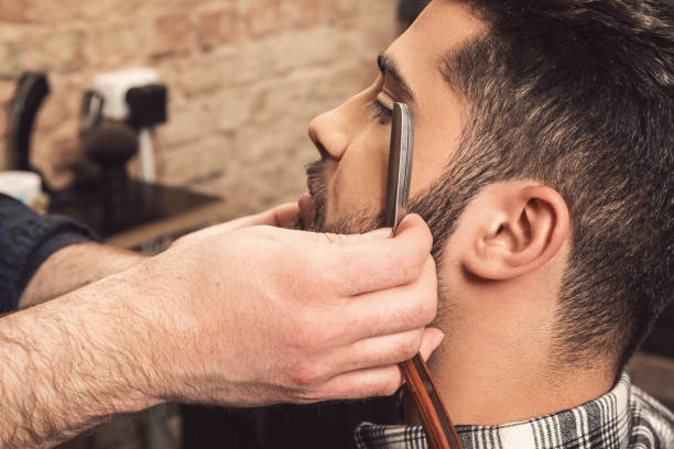 istock Barber working with a straight razor 1178585617