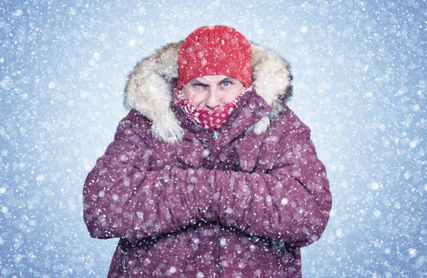 istock Frozen man in red winter clothes warms his hands, cold, snow, frost, blizzard 1178589164