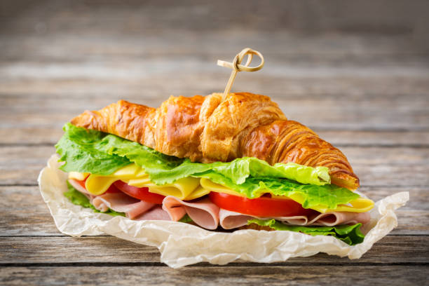 istock Fresh croissant sandwich with ham, cheese, lettuce and tomato 1178590280