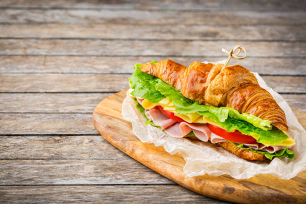 istock Fresh croissant sandwich with ham, cheese, lettuce and tomato 1178590281