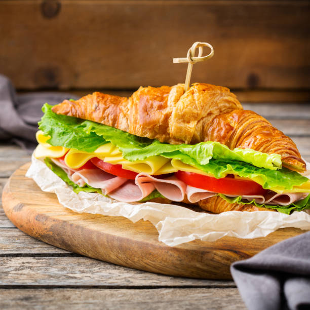 istock Fresh croissant sandwich with ham, cheese, lettuce and tomato 1178590311
