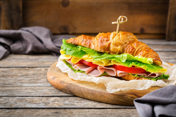 istock Fresh croissant sandwich with ham, cheese, lettuce and tomato 1178590313