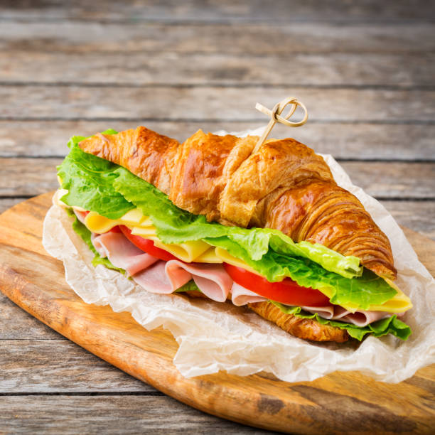 istock Fresh croissant sandwich with ham, cheese, lettuce and tomato 1178590328