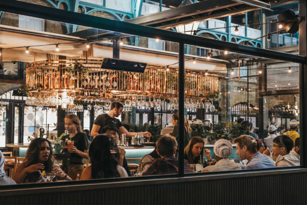 vue à travers la fenêtre du personnel et des clients à l'intérieur du restaurant buns and buns à covent garden market, londres, royaume-uni. - cohue photos et images de collection