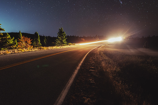 Car travels on a coastal highway on a clear Autumn night.  Long exposure.