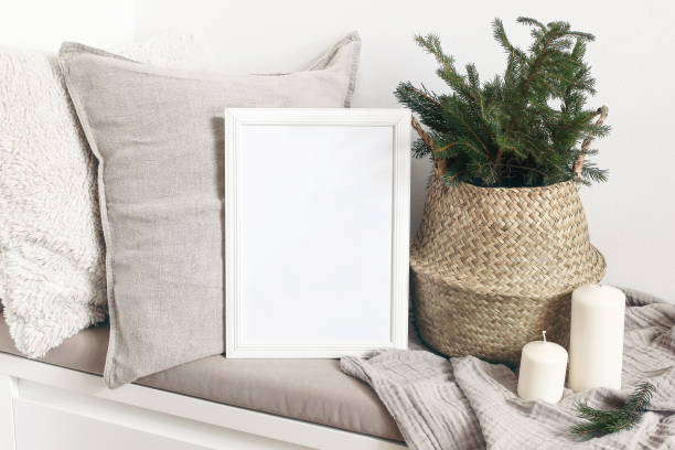 White blank wooden frame mockup with Christmas tree, candles, linen cushions and plaid on the white bench. Poster product design. Scandinavian home decor, nordic design. Winter festive concept. White blank wooden frame mockup with Christmas tree, candles, linen cushions and plaid on the white bench. Poster product design. Scandinavian home decor, nordic design,inter festive concept. checked pattern photos stock pictures, royalty-free photos & images