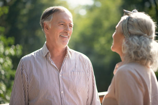 istock Grey-haired bearded man laughing while talking to wife 1178593024