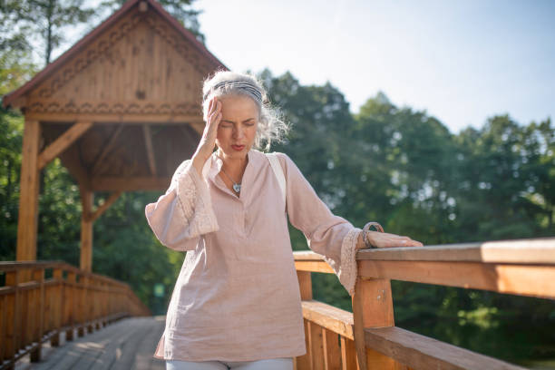 Woman suffering from headache while walking in the park