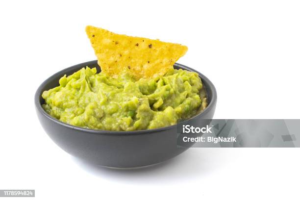 Green Guacamole With Nachos In Dark Bowl Isolated On White Background Stock Photo - Download Image Now