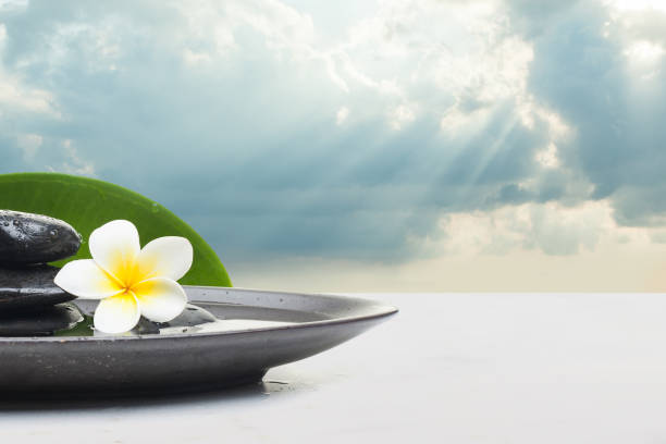 istock Spa Set with flower stones for massage treatment on black plate. 1178596510