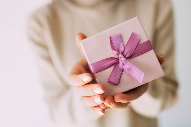 istock Female hands holding gift box with pink ribbon. 1178600338