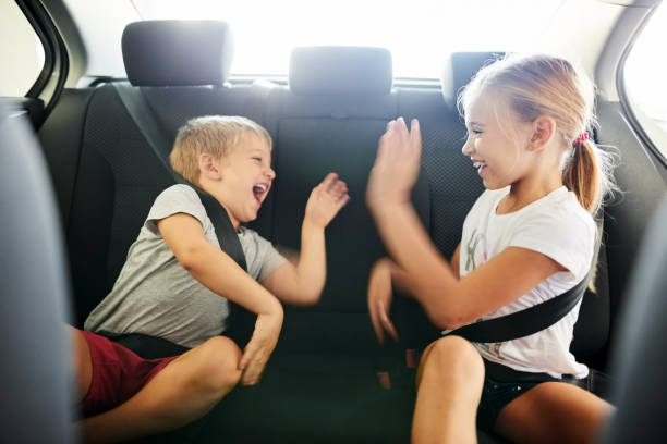 Children playing while traveling Shot of cute little boy and girl playing while traveling by car back seat photos stock pictures, royalty-free photos & images