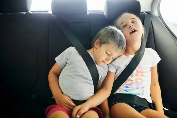 Shot of two little children sleeping in car while travelling