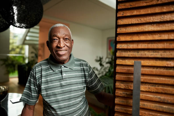 Senior man opening the front door Shot of happy senior african man opening the door front door photos stock pictures, royalty-free photos & images