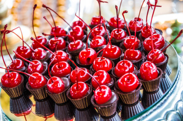 Fine chocolate candy with red cherries decorating party table.